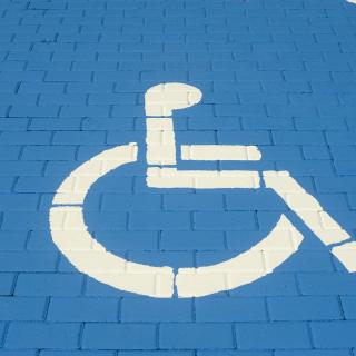 Blue painted brick parking spot with a white wheelchair icon.