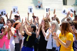 A crowd of Unitarian Universalists cheers in front of the US Supreme Court.