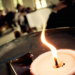 A flame rises from the flaming chalice, a symbol of Unitarian Universalist faith.