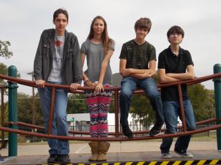 Four young people stand on a bridge to symbolize their transition from childhood to adolescence.