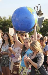 Young woman holds plastic earth ball at rally for environmental justice in Louisville, KY, June 2011.