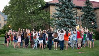 Group of people raising their arms in the air.