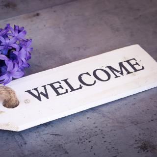 Welcome on a wooden tag attached to a hyacinth