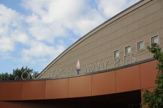 The outside of a UU congregation's building, reading "One Church Many Paths"