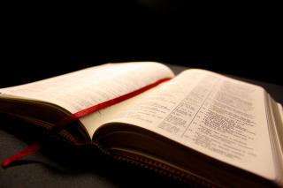 An open Bible with a red ribbon bookmark