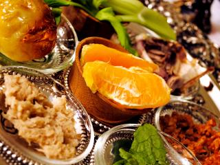 A prepared seder plate with orange slices in the center.