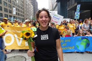 Young woman holding sunflowers with more UUs in background at 2014 People's Climate March in New York City.