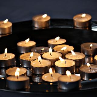 Small tea light candles lit and collected on a tray