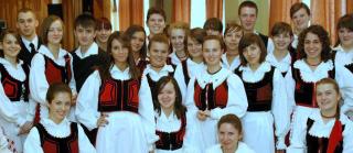 A group of young Unitarians from the Transylvania region of Romania smile, wearing traditional ethnic clothes.