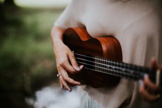 A woman's hands cradle a ukelele