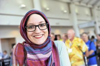 A young UU woman in a headscarf smiles.